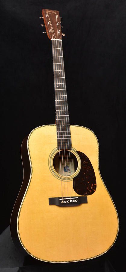 Dreadnought acoustic guitar with natural top and dark pickguard, front view