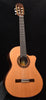 Cutaway classical guitar with decorative rosette and natural wood body, standing upright