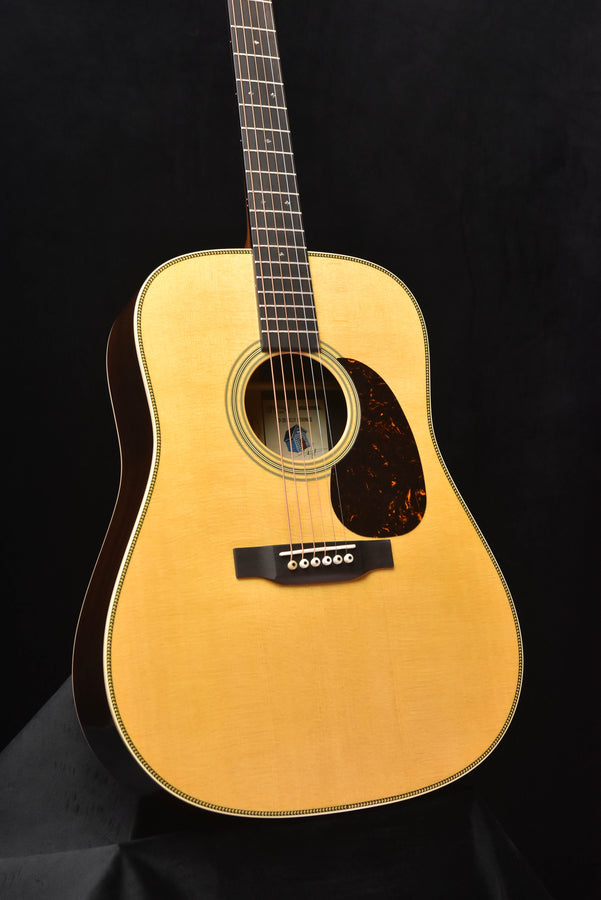 Dreadnought acoustic guitar with natural wood finish, sound hole and pickguard