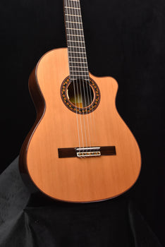 cutaway classical guitar with natural wood finish, decorative rosette, and bridge