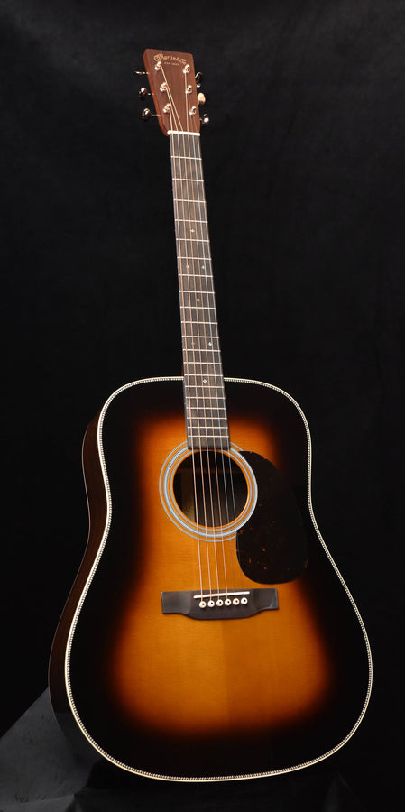 Sunburst acoustic guitar with white rosette, white binding, and black pickguard