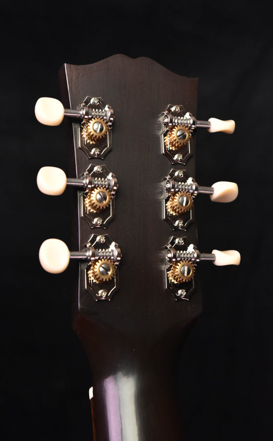Gibson acoustic guitar headstock back with six tuning pegs and engraved tuner plates