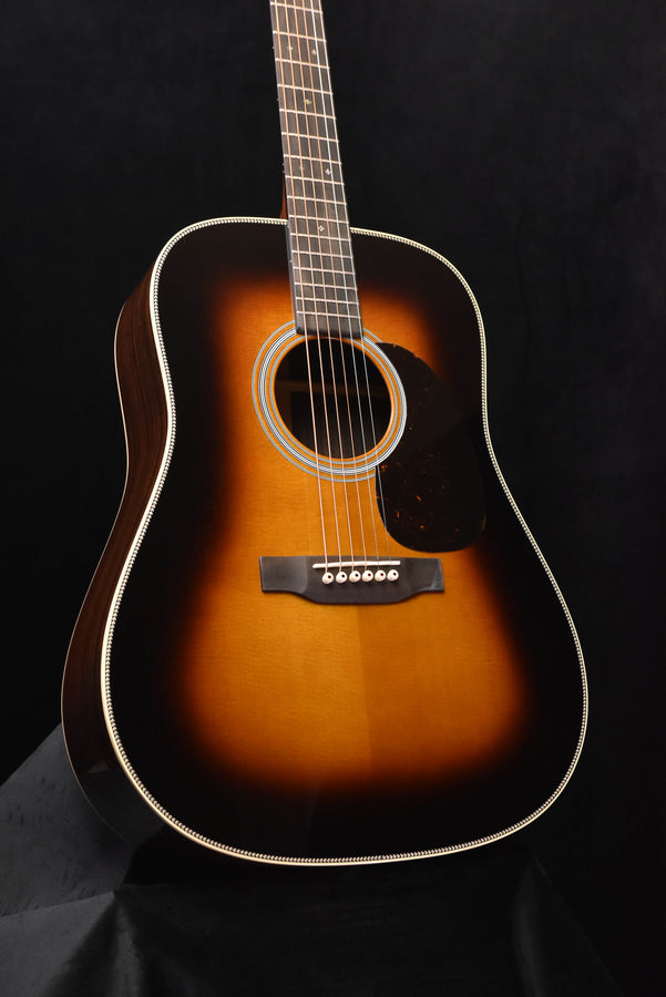 Sunburst acoustic guitar front view with white binding and black pickguard