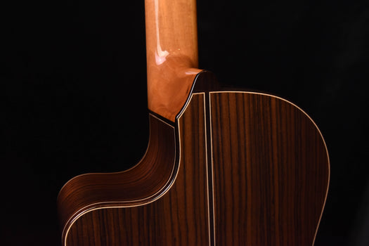 cutaway classical guitar neck joint close-up with glossy finish and binding