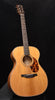 Acoustic guitar with natural wood body, sound hole rosette, and dark fretboard