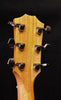Acoustic guitar headstock with six tuning machines and visible string posts
