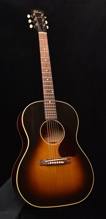 Acoustic guitar with sunburst finish, rosette sound hole, and bridge with saddle
