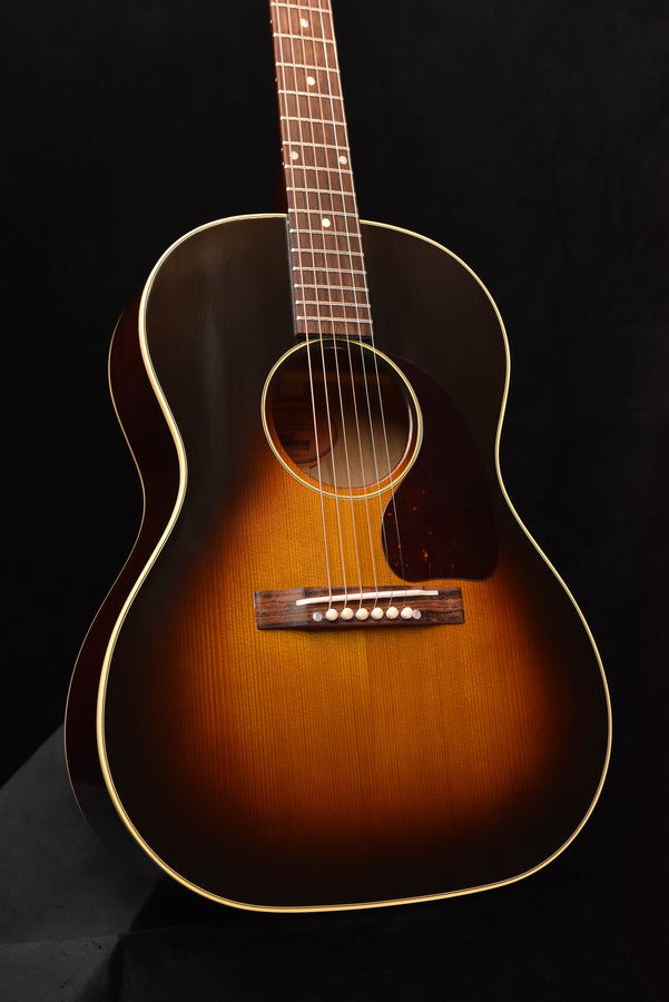 Acoustic guitar front view with sunburst body, sound hole rosette, and pickguard
