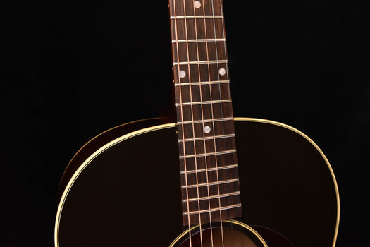 acoustic guitar close-up of neck and fretboard with body sound hole and binding