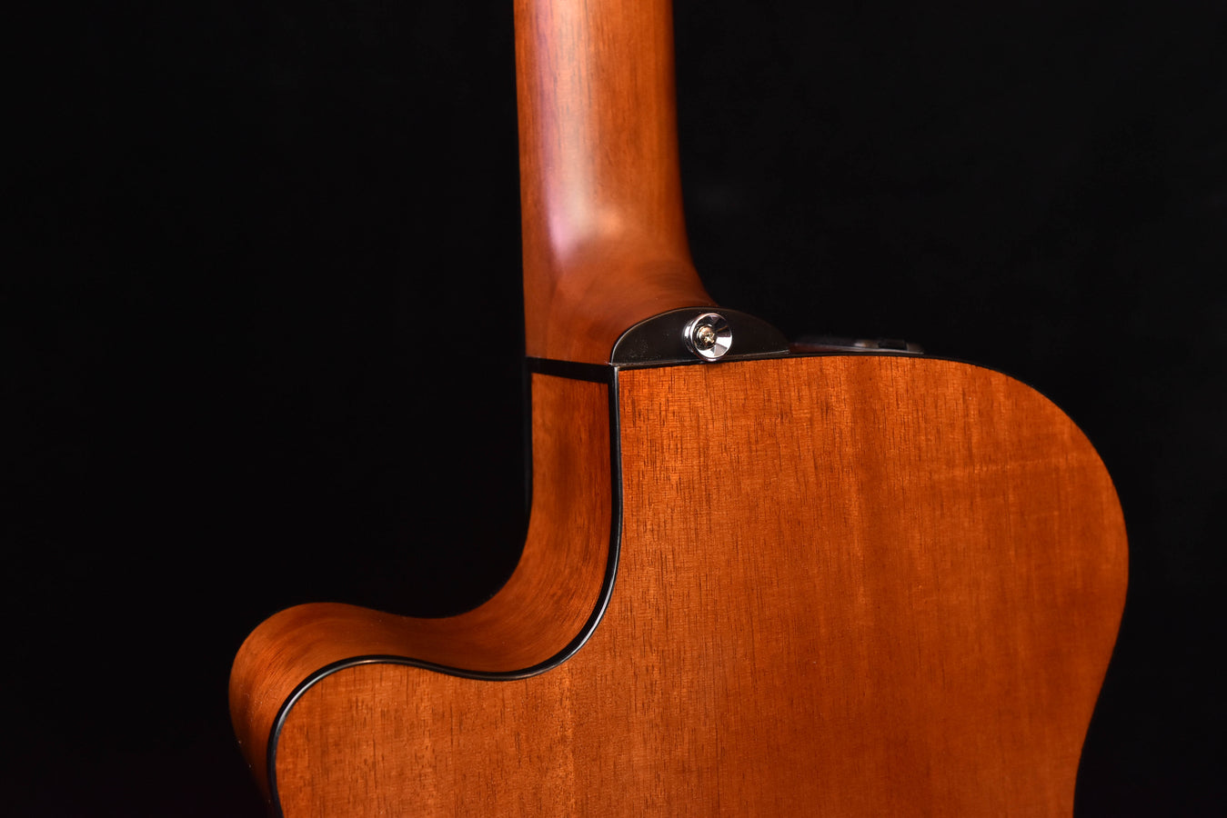 Cutaway side view of acoustic-electric crossover guitar, natural wood and binding