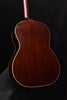 Acoustic guitar back close-up with glossy dark wood grain and cream binding