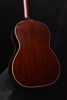 acoustic guitar back close-up with glossy dark wood grain and cream binding