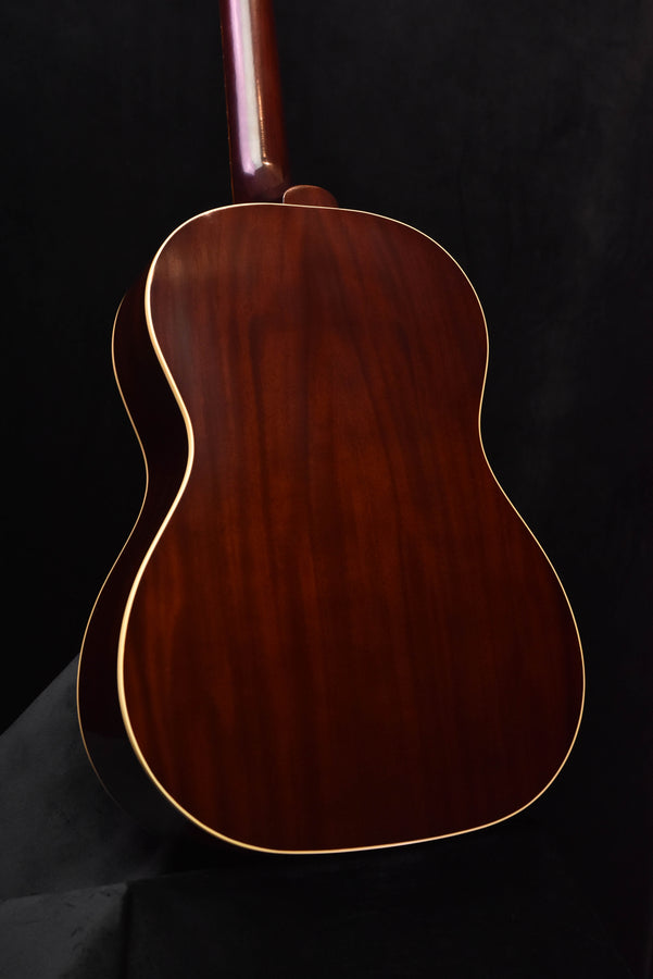 Acoustic guitar back close-up with glossy dark wood grain and cream binding