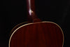 Acoustic guitar body close-up with glossy dark wood and cream outline binding