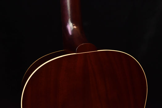 acoustic guitar body close-up with glossy dark wood and cream outline binding