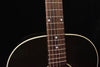 Acoustic guitar neck and headstock area with dot inlays and sound hole edge