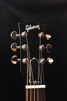 gibson acoustic guitar headstock close-up with chrome tuners