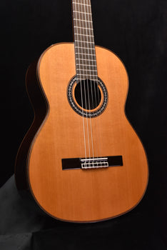 classical nylon-string guitar with natural wood finish and black pickguard