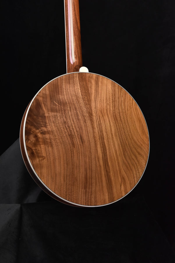 Brown wooden banjo body with white binding and upright neck