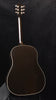 Hollow-body acoustic guitar with dark top, glossy finish, and chrome tuners