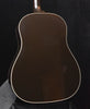 Hollow-body acoustic guitar body with dark top and white binding outline