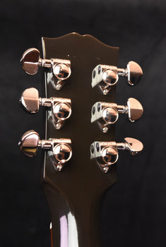 gibson acoustic guitar headstock close-up with six chrome tuning pegs