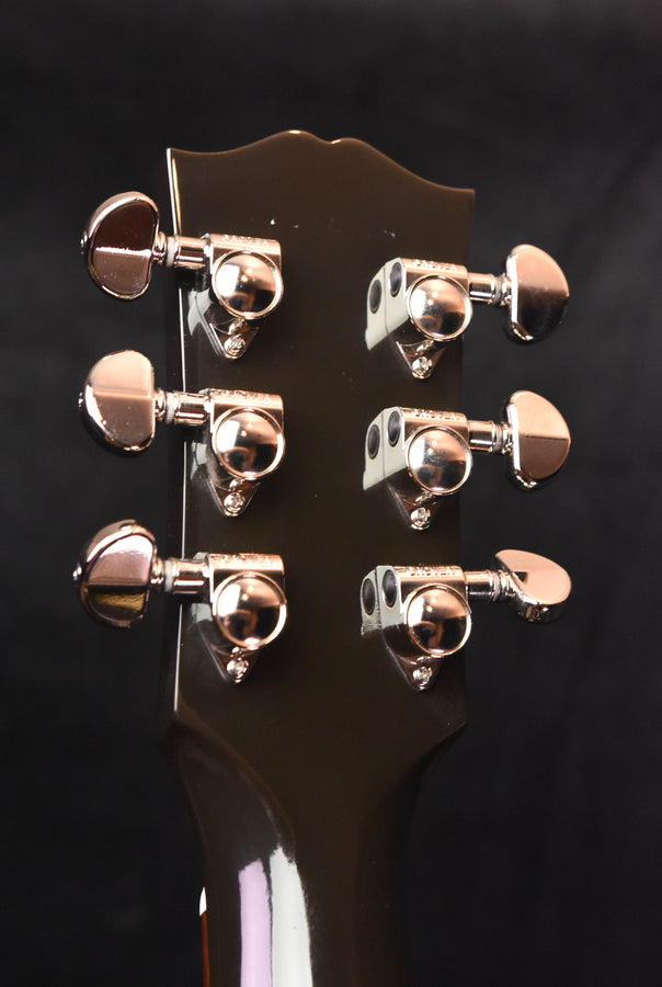 Gibson acoustic guitar headstock close-up with six chrome tuning pegs