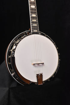 banjo with white drumhead, dark metal rim, and neck with frets and strings