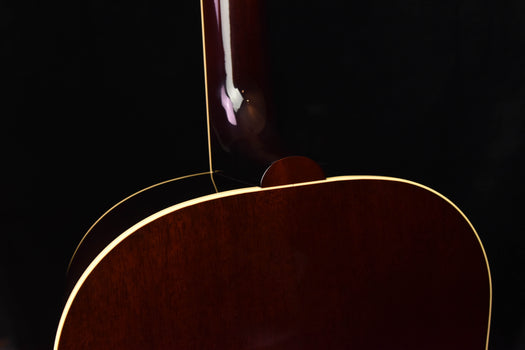 brown acoustic-electric guitar top with arched cutaway near the soundhole