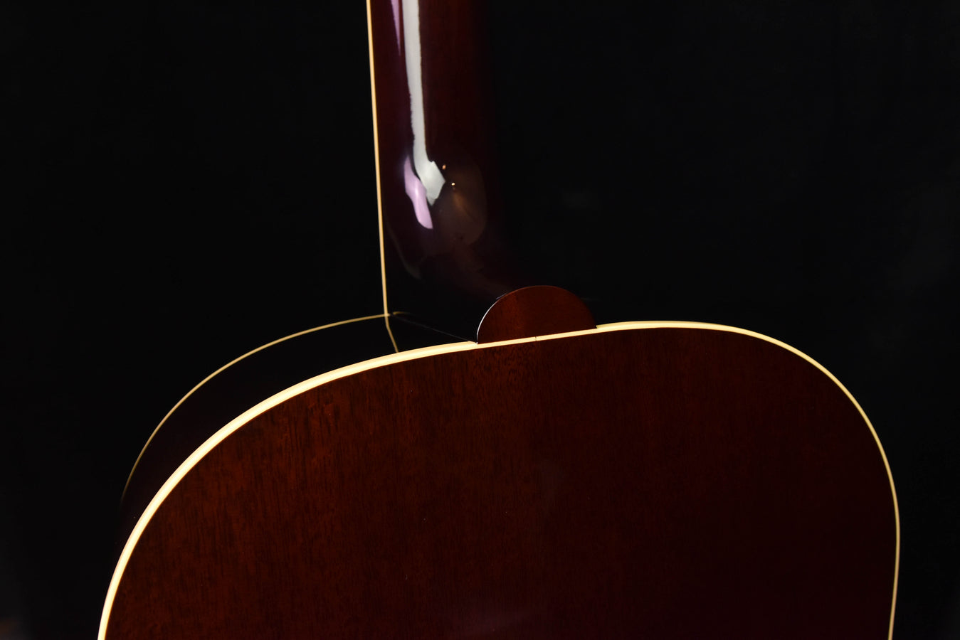 Brown acoustic-electric guitar top with arched cutaway near the soundhole