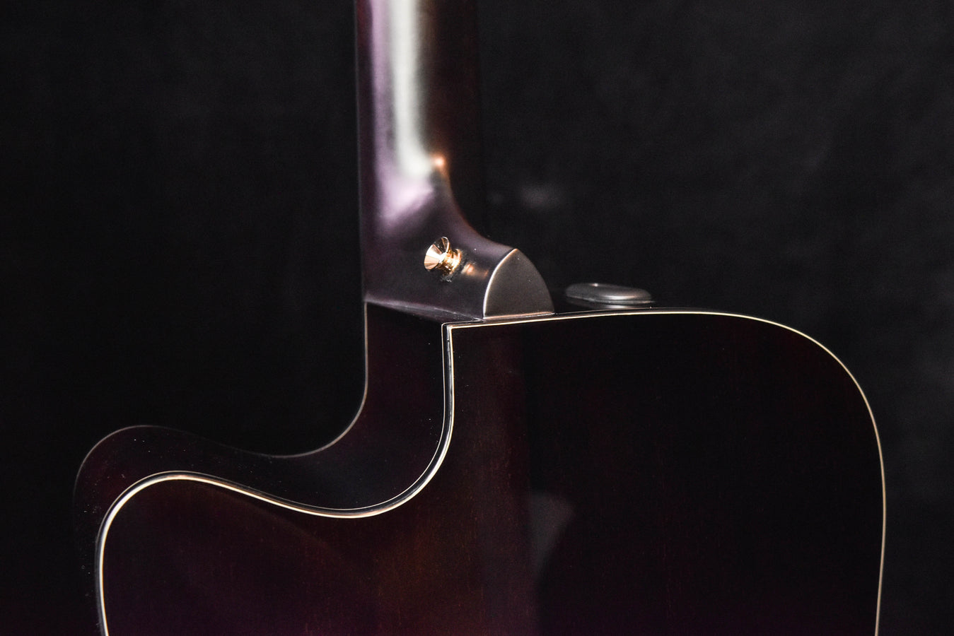 Neck-to-body joint on dark-finished acoustic guitar