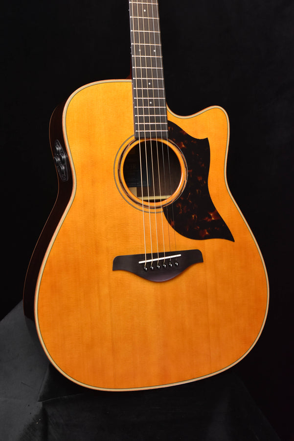 Natural acoustic/electric guitar, round soundhole and pickup/pickguard detail visible