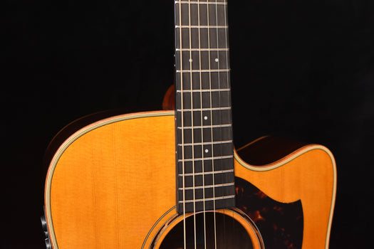 close-up of the guitar neck and fretboard with the round soundhole in frame