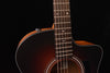 Acoustic guitar close-up on strings, fretboard, and upper body edge.