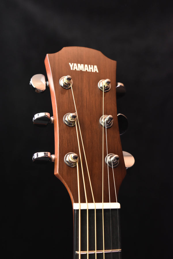 Yamaha guitar headstock with six tuning pegs and Yamaha logo on dark wood