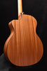 Acoustic guitar back close-up with natural wood grain and side binding.