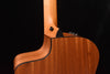 Acoustic guitar side view showing neck joint and body contour in natural wood.