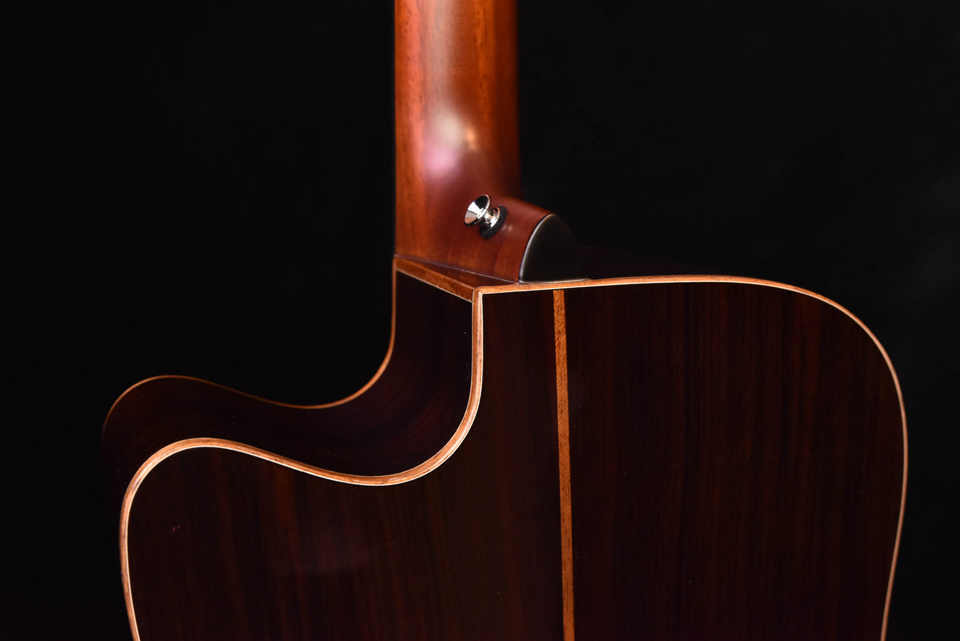 Side view of acoustic/electric guitar body showing neck joint and dark edge binding