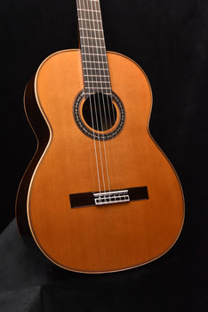 classical guitar in natural wood with rosette sound hole and fixed bridge.