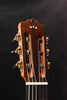 Classical guitar headstock with tuning pegs on both sides, warm wood tone.