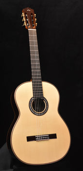 light wood classical acoustic guitar with rosette sound hole and black bridge