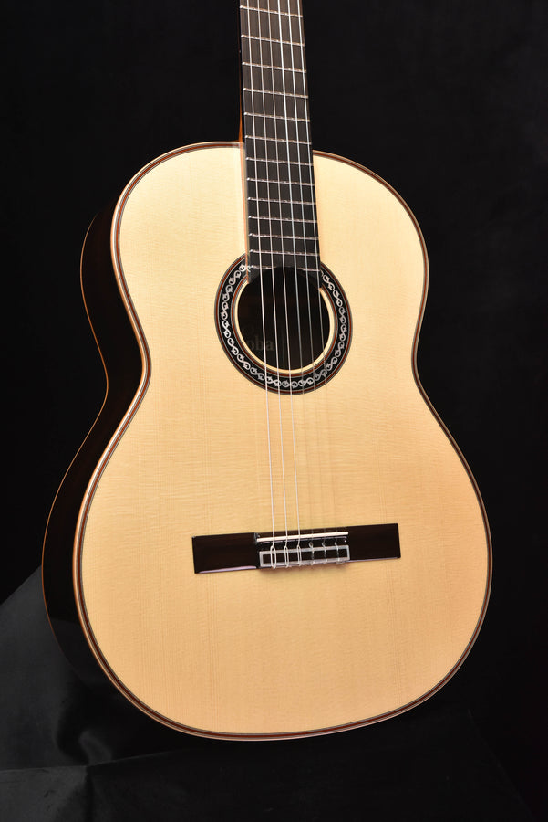 Light wood classical acoustic guitar front view with rosette sound hole and bridge