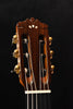Dark wood classical guitar headstock with gold tuning pegs and strings