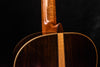 Close-up of classical guitar neck and upper body on dark wood finish