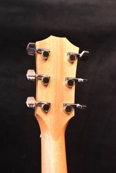 acoustic guitar headstock with six tuning machines and natural wood top