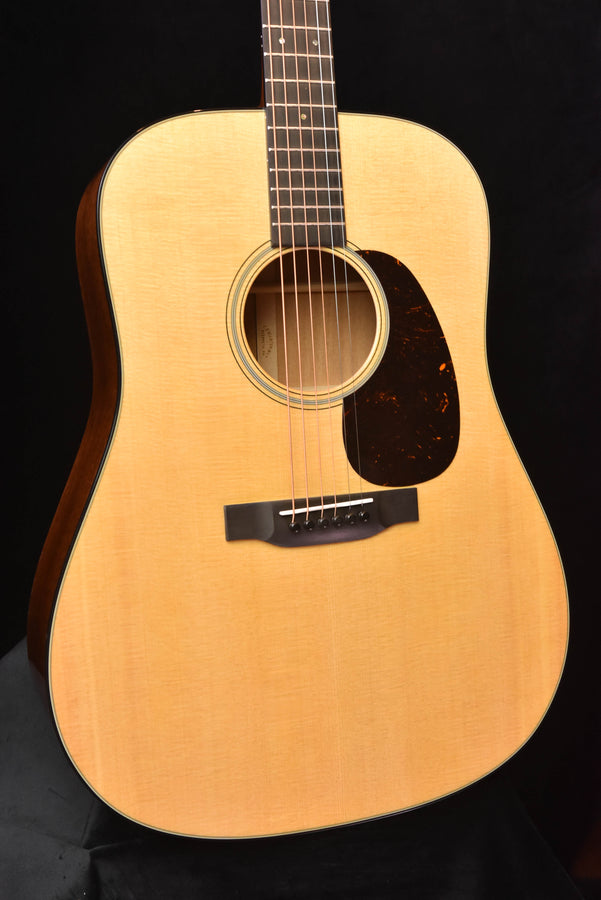 Front view acoustic guitar with round soundhole and dark pickguard
