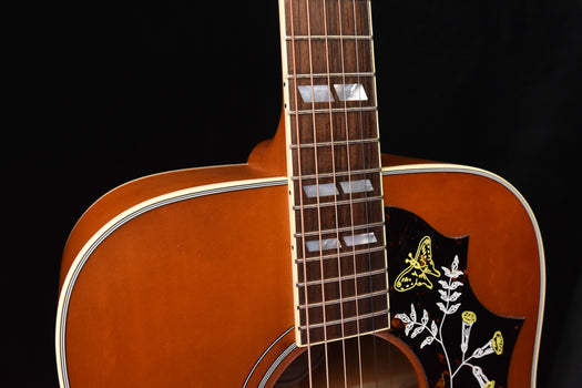 dreadnought acoustic guitar with fretboard and hummingbird inlay on pickguard