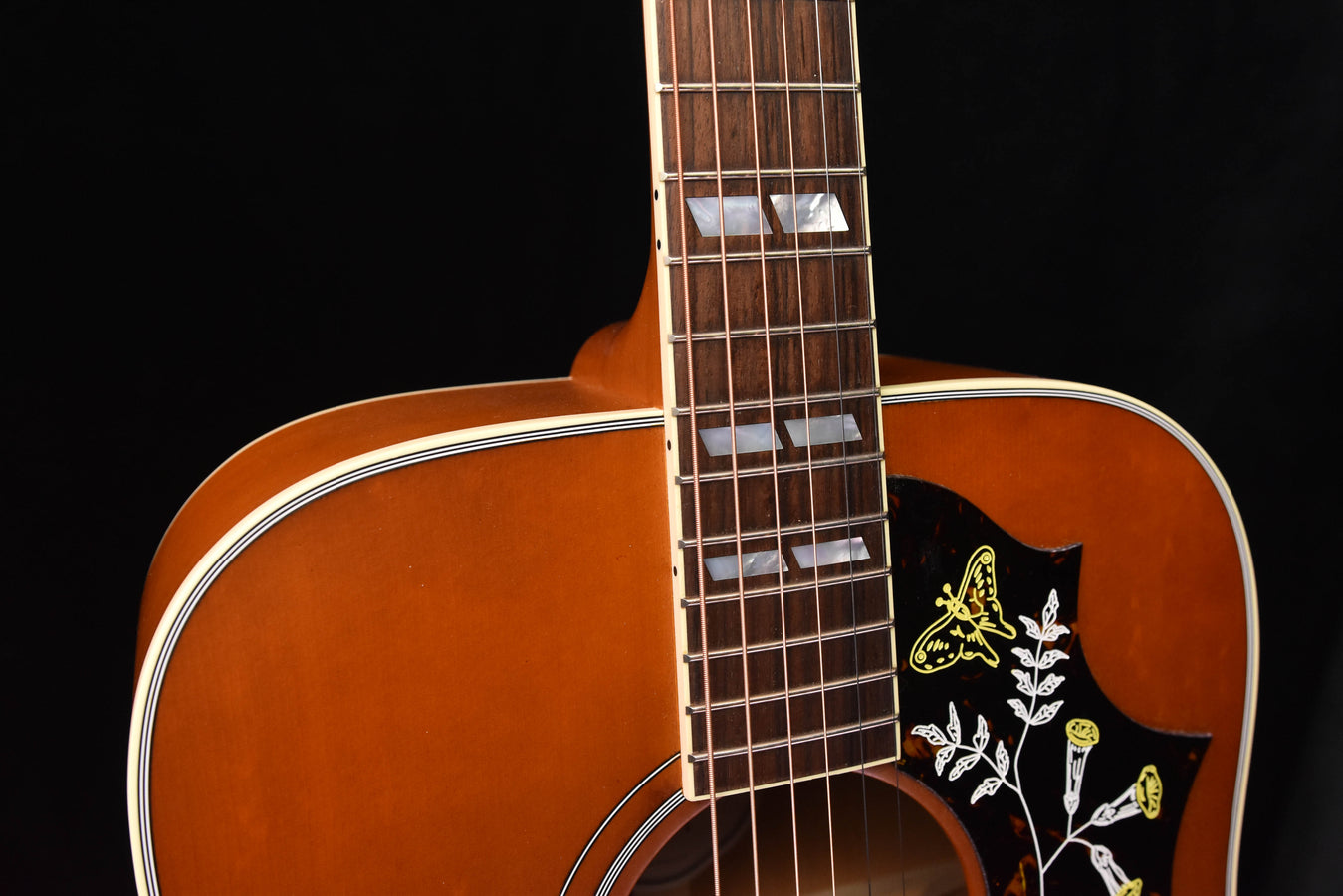 Dreadnought acoustic guitar with fretboard and hummingbird inlay on pickguard