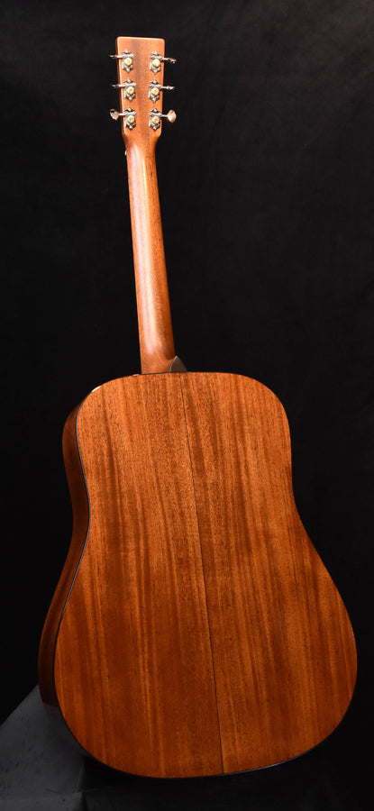 Back of acoustic guitar with warm brown wood grain and neck