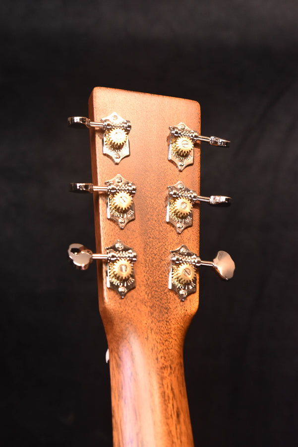 Acoustic guitar headstock showing six tuning pegs and machine heads